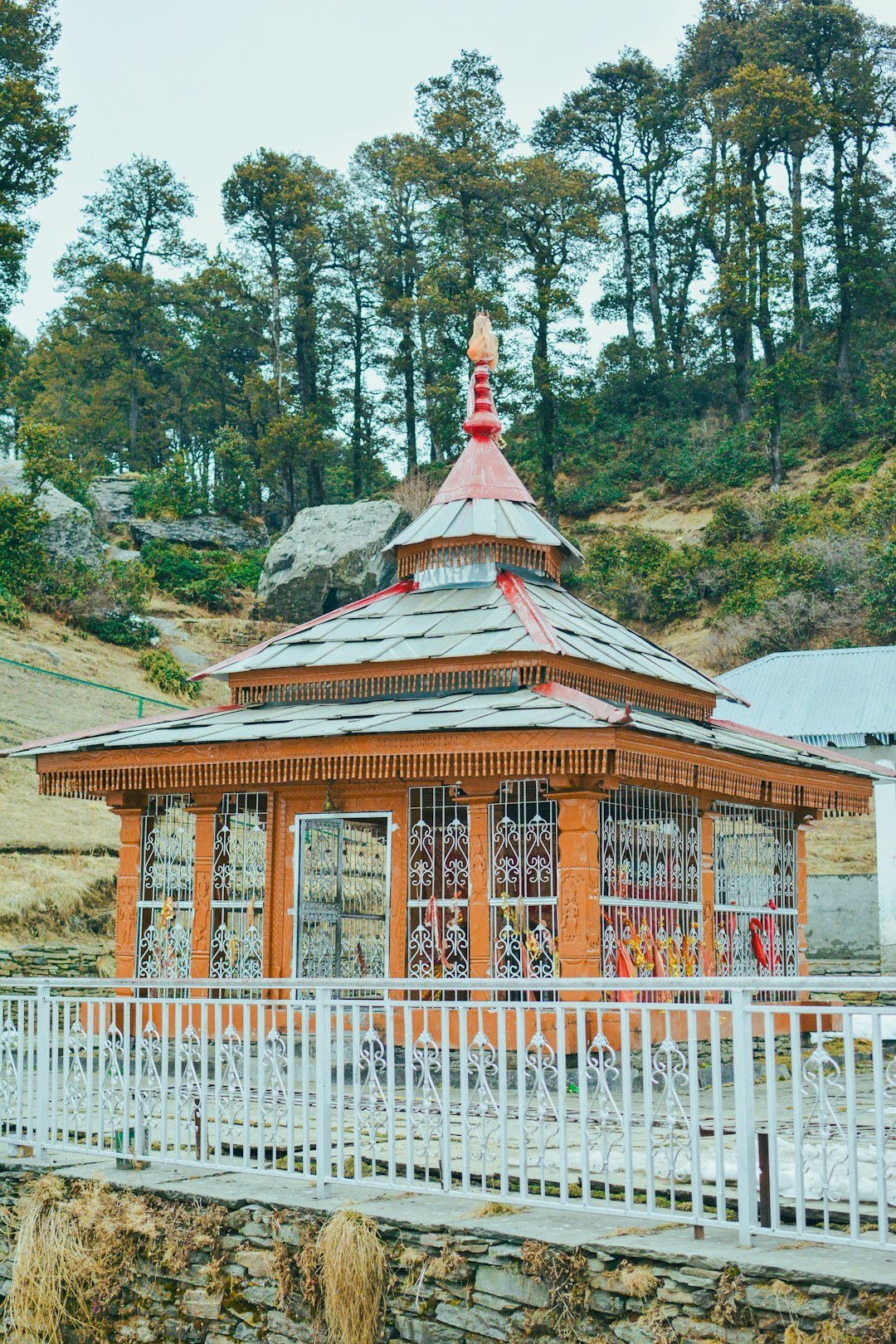 a-small-building-with-a-white-fence-around-it-mwlbwboymoy